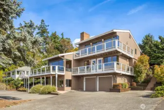 Welcome home! Expansive view decks and walls of windows capture the stunning westerly panoramas of Puget Sound and the Olympic Mountains. Generous parking and a private entry—accessed by the stairs to the right—make this home as practical as it is picturesque.