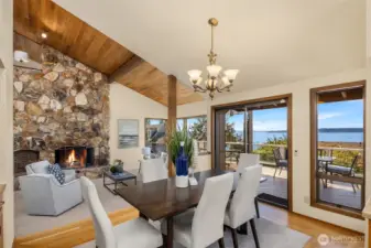 The dining room offers vaulted ceilings, wood floors with a carpet inlay, and expansive windows with a glass slider that beautifully frame the stunning views.