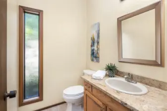 The main-level powder room features slab granite counters and classic finishes.