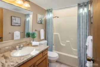 The second bath on the main level is a full bathroom, while a separate powder room nearby provides convenience for guests.
