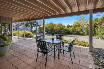 The covered front patio offers views and easy access to the driveway and front sports court.