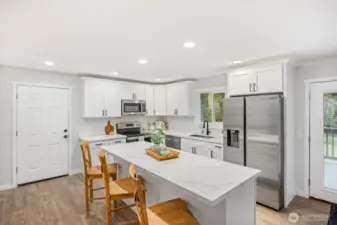 Kitchen with quartz counters, white cabinets and stainless steal appliances