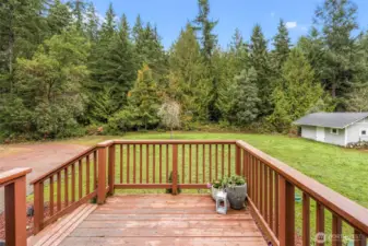 Porch overlooks property and shed