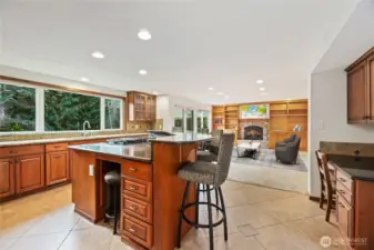 Expansive center island with prep space and seating, complemented by a desk to the right. Barstools and kitchen desk chairs can stay if desired. Image is virtually staged for visualization purposes.