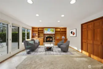 The family room features custom built-ins, abundant natural light and a sliding glass door that opens to the deck. Image is virtually staged for visualization purposes.