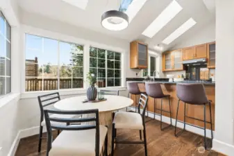 Informal eating space ensconced in light and surrounded by windows and lush greenbelt