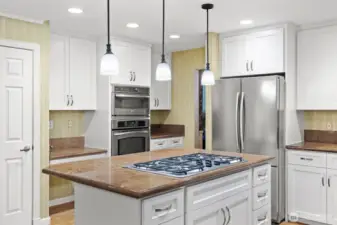 Chef-inspired five-burner gas cooktop with telescoping downdraft vent.