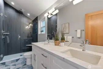 Custom tile bathroom with a vaulted ceiling shower and a double vanity.