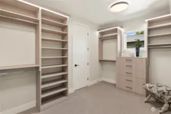 The Primary Bedroom closet is a masterfully designed space, featuring custom-built shelves and drawers for optimal organization. A charming clerestory window lets in an abundance of natural light, creating a bright and inviting atmosphere.