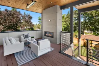 The back deck located off of the kitchen with easy care composite wood construction, knotty pine ceiling, electric fireplace, ceiling heater and TV outlet.  The stairs go down to the driveway and yard.