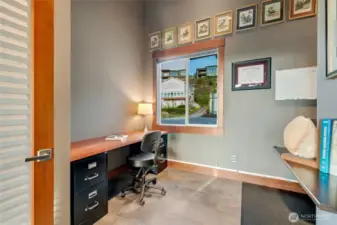 A dedicated office space with built-in cabinetry and a large window creates a bright and efficient workspace.
