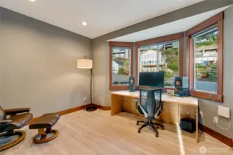 A spacious flex room with large bay windows offers the perfect setup for a home office, studio, or creative space.