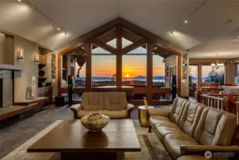 A stunning wall of floor-to-ceiling picture windows frames breathtaking sunset views and floods the living space with natural light.