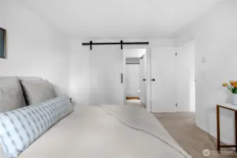 alternate primary suite view with barn door to en-suite bathroom for added privacy
