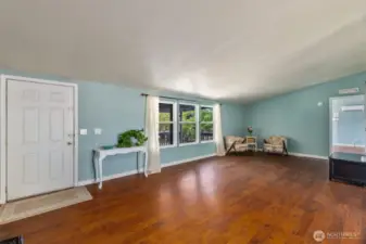 Spacious living space with beautiful laminate hardwood floors and vaulted ceilings.