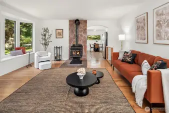 Looking through the living room with wood stove, bay window seat and doorway into kitchen. Great space for game nights.