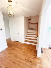Gleaming oak hardwoods in entryway, spacious cedar coat/storage closet to left of stairs