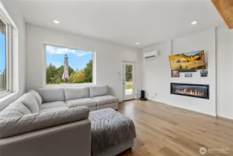 Electric fireplace, mini split and large windows enhance the lighting