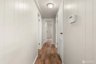 Hallway leads to both bedrooms and bathrooms.