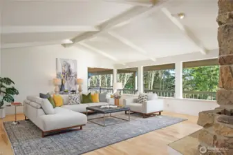 With 4,940 sf of living space this home lives large as seen in this formal living room with wall-to-wall windows and open beam vaulted ceilings.