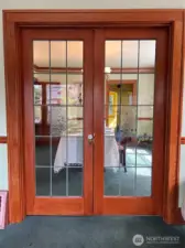 Extensive woodwork with leaded glass window french doors.