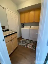 Downstairs laundry room with utility sink.