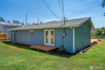 Back of the house with small deck off the primary bedroom.
