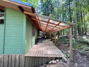 Large covered back porch looking out into the woods beyond