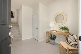The bright and spacious entryway features neutral ceramic tile and a spacious coat closet.