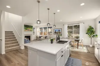 The main level is flooded with light, featuring neutral paint, beautiful laminate wood flooring, quartz counters, and spacious open-floorplan living.