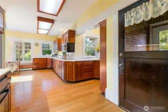 This door to the right, just off the kitchen, leads you to the enclosed back entry often used as a mudroom and a pantry or storage.