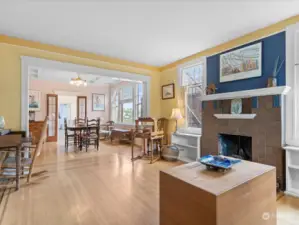Enter into the spacious living room, with the original fireplace mantel and built-in bookshelves on either side.