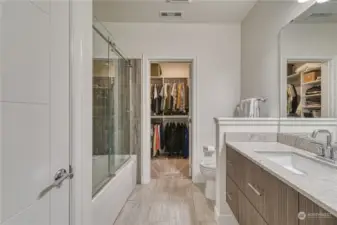 Primary bathroom with tile floors and shower surround, glass doors and granite counter tops.