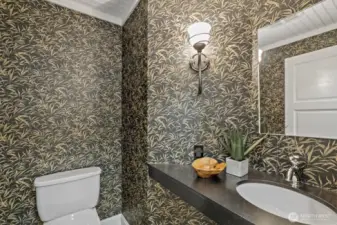 The guest 1/2 bath has been updated with a floating vessel sink, slate floor and designer wallpaper.
