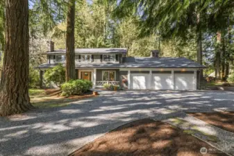 The circular drive leads toward the front covered Ironwood deck with Mahogany front door.