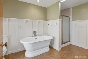 Primary bathroom with freestanding soaking tub and walk-in shower!  The wainscoting with picture rail adds character to the space!