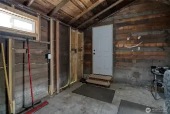 Unfinished, enclosed mud room which connects the garage door and back door of house