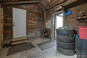 Unfinished, enclosed mud room which connects the garage door and back door of house