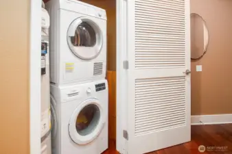Utility closet near the unit entry houses a stacked washer and dryer, plus nearly new hot water tank.
