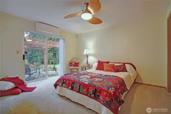 Primary bedroom. Slider leads to romantic pergola-covered garden patio. Minisplit for year round comfort. Ceiling fan on remote.