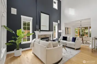 The living room is spacious and bright, with a cozy fireplace, hardwood floors, and a stylish accent wall.