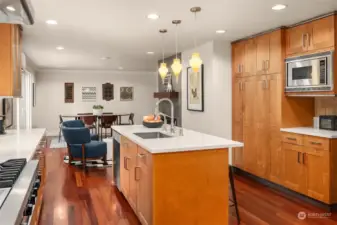 Warm rich cabinetry throughout allows for so much storage and plays beautifully with the white quartz surfaces.