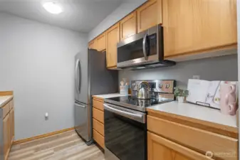 Kitchen features newer moden SS appliances including range, oven, microwave and fridge