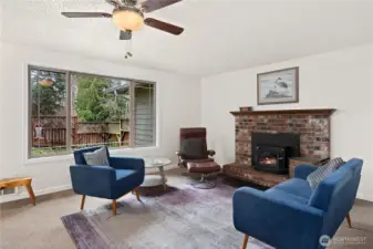 Wood fireplace and ceiling fan, plus a large picture window to the flowering yard. No lawn!