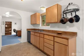 Kitchen counter has a deep two-compartment sink, garbage disposal and and a pot rack.