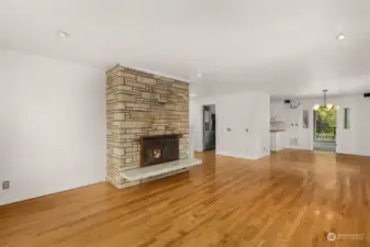 Family room with fireplace, hardwood flooring, fresh paint, and a view.