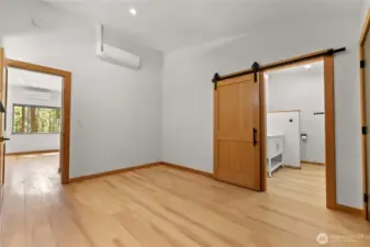 Primary bedroom on main floor with access to dining area and ensuite bathroom seen in this photo.