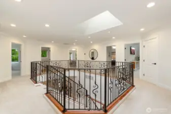 Upon exiting the primary suite, you'll enter the circular hallway with sightlines to the other three bedrooms, bonus room, to bathrooms, and laundry. Such a cool layout that brings in so much light.