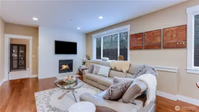 Family room with custom tile surround gas fireplace open to breakfast nook & kitchen. Main floor Bedroom staged as office.