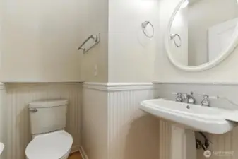 The main-level powder room is perfect for guests, offering convenience and style with a thoughtfully designed space just off the main living areas.